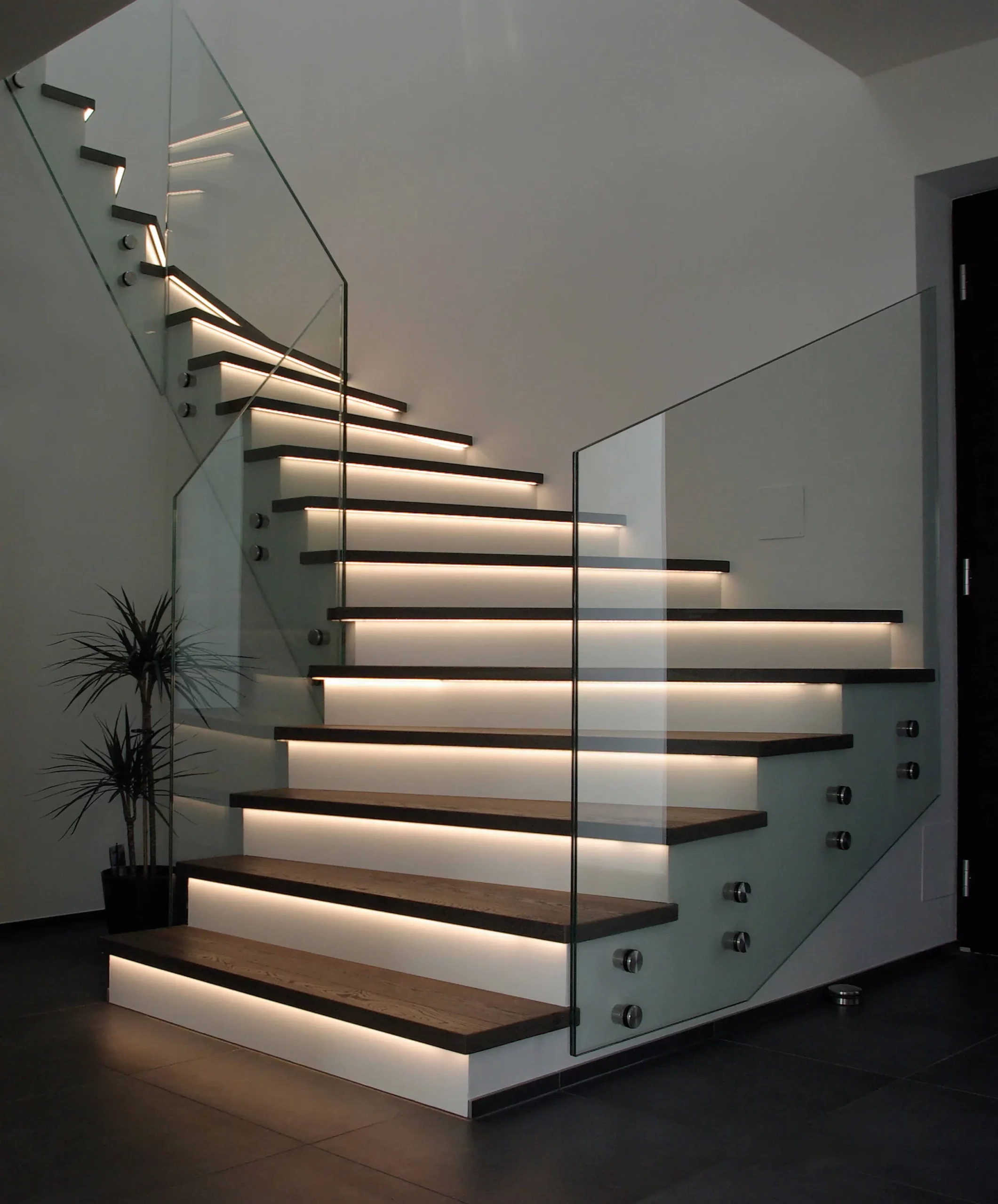 Eine moderne Treppe mit Glasgeländer und LED Beleuchtung an den Treppen - Stufen. Lauer maler & raumdesign - Bodenbeläge, Vinylboden, Farben, Sonnenschutz, Malerarbeiten - Bahnhofstr. 5a - 36280 Oberaula